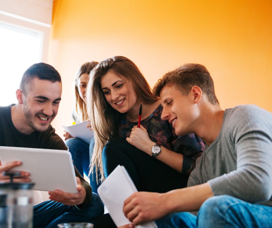 Happy students working around device